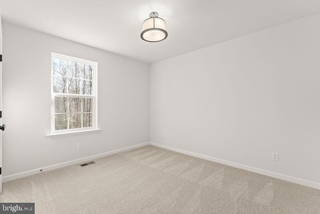 empty room with visible vents, baseboards, and carpet floors