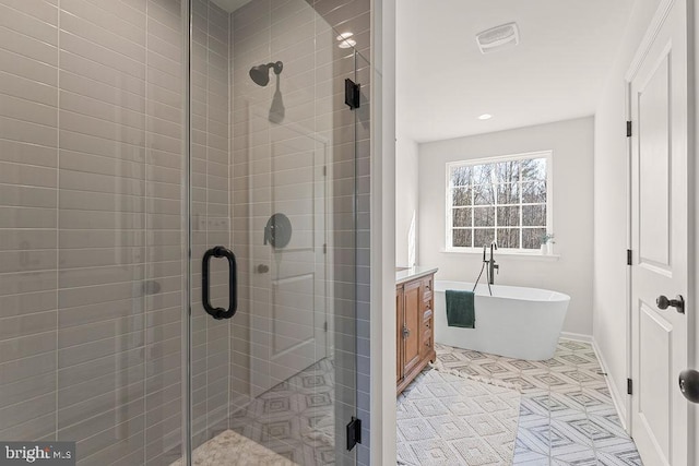 full bath featuring vanity, baseboards, visible vents, a freestanding bath, and a shower stall