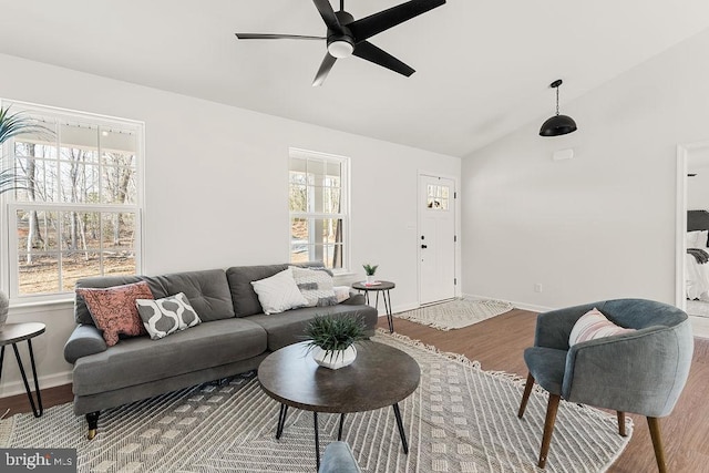 living room with wood finished floors, baseboards, lofted ceiling, and ceiling fan