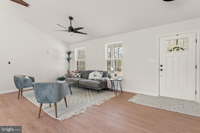 foyer entrance featuring lofted ceiling, baseboards, light wood finished floors, and ceiling fan