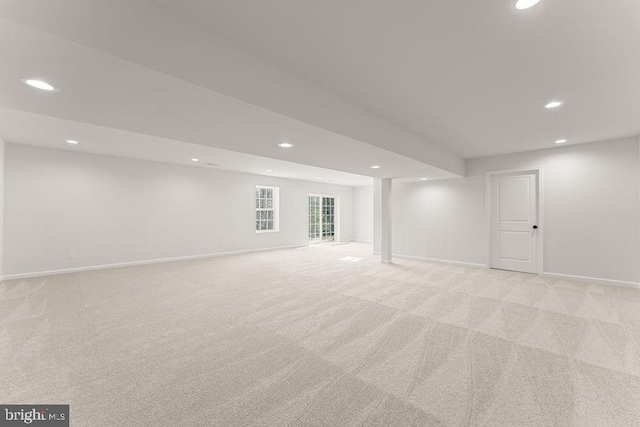 below grade area featuring recessed lighting, light colored carpet, and baseboards