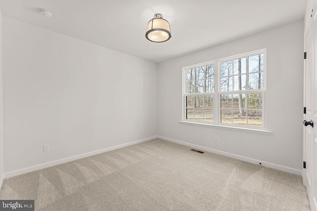 unfurnished room featuring visible vents, carpet floors, and baseboards