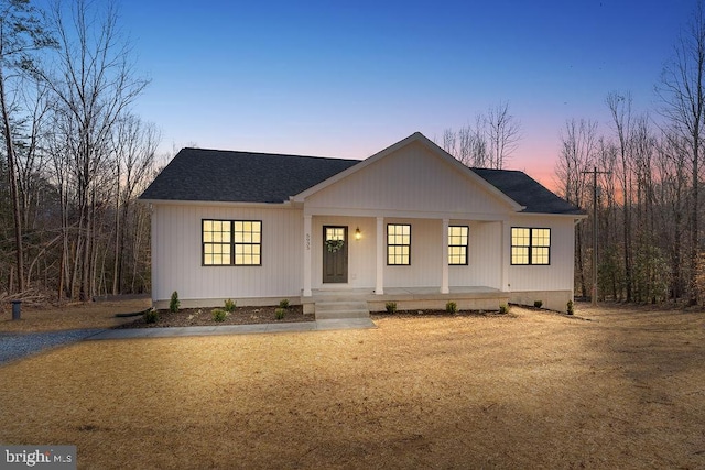 modern inspired farmhouse with a porch and a shingled roof