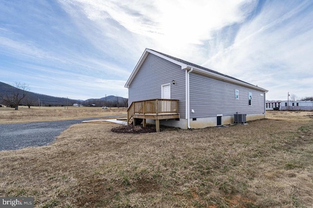 view of property exterior with cooling unit and a mountain view