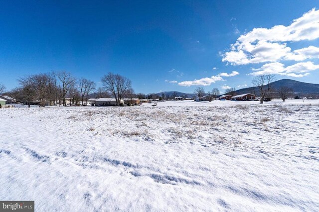 snowy yard featuring a mountain view