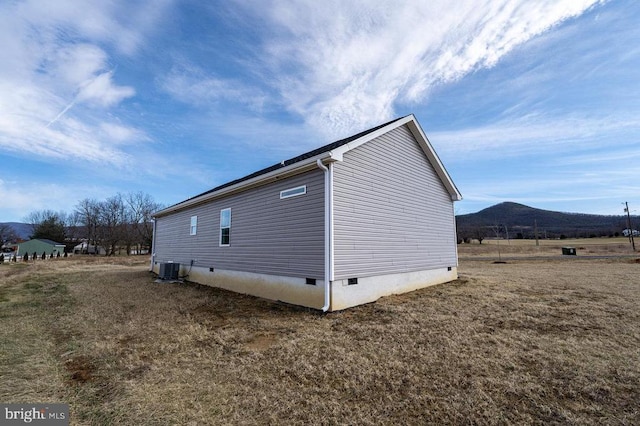 view of side of property with crawl space and a mountain view