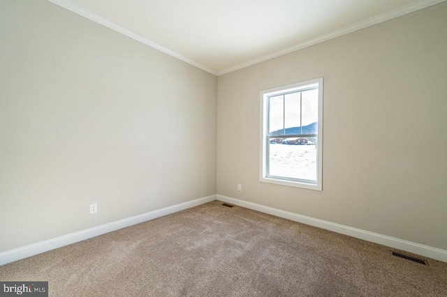 empty room featuring ornamental molding, carpet flooring, visible vents, and baseboards