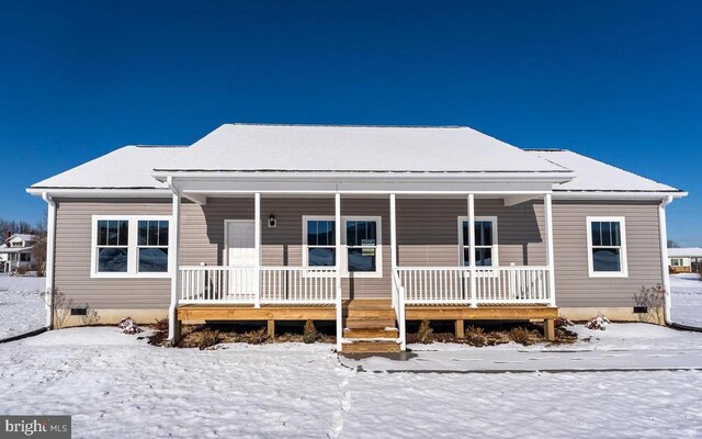 snow covered property featuring a porch and crawl space