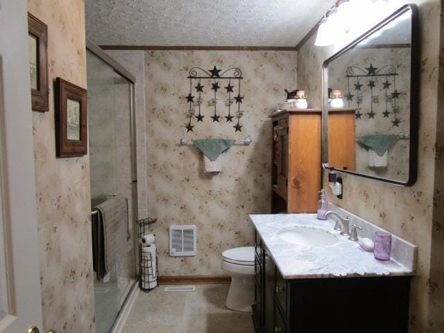 full bath with wallpapered walls, a stall shower, toilet, a textured ceiling, and vanity