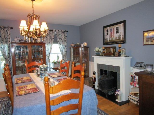 dining room with a chandelier, a fireplace with flush hearth, and wood finished floors