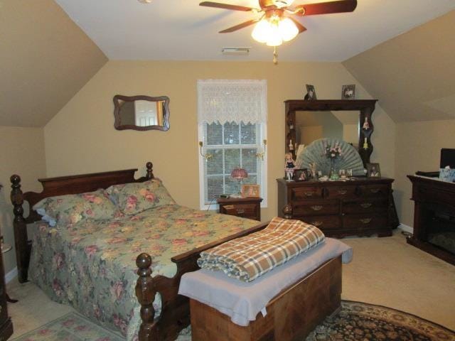 bedroom with a ceiling fan, visible vents, vaulted ceiling, and carpet flooring