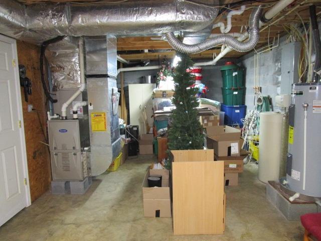 utility room featuring heating unit and gas water heater