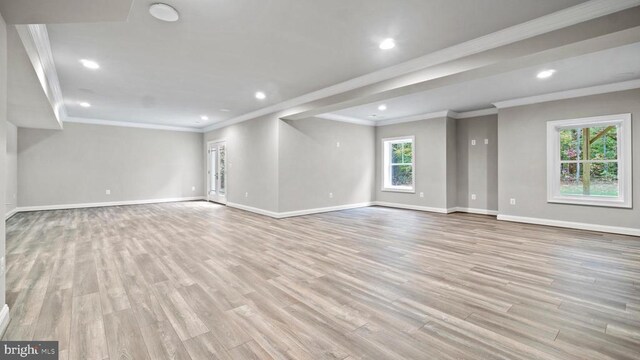 unfurnished living room featuring ornamental molding and light wood-type flooring