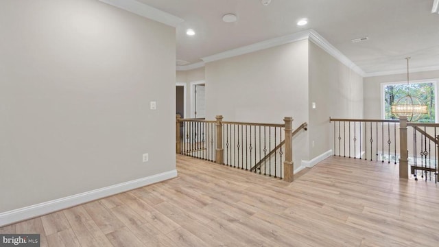 interior space featuring ornamental molding, a chandelier, and light hardwood / wood-style floors