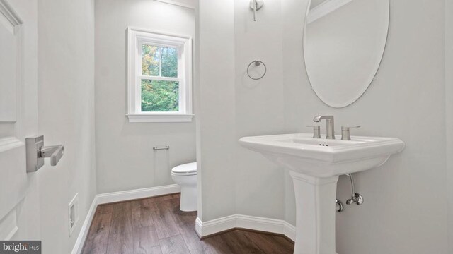 bathroom featuring wood-type flooring and toilet