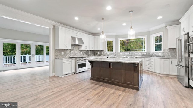 kitchen featuring white cabinetry, high end appliances, a center island, and light stone counters