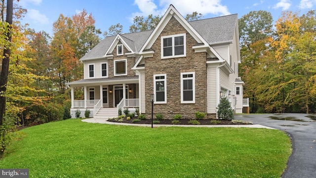 craftsman-style house featuring a garage, a front yard, and covered porch