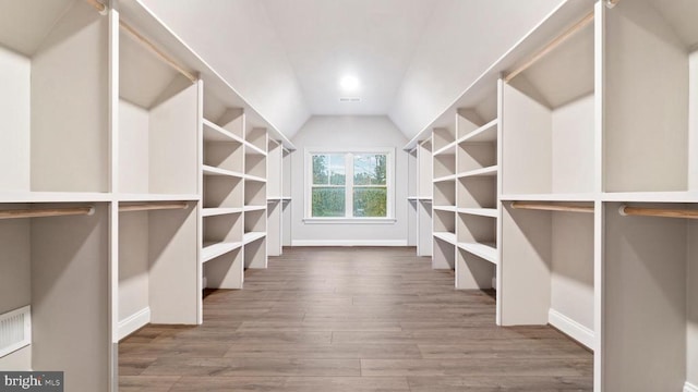 spacious closet featuring hardwood / wood-style flooring and vaulted ceiling