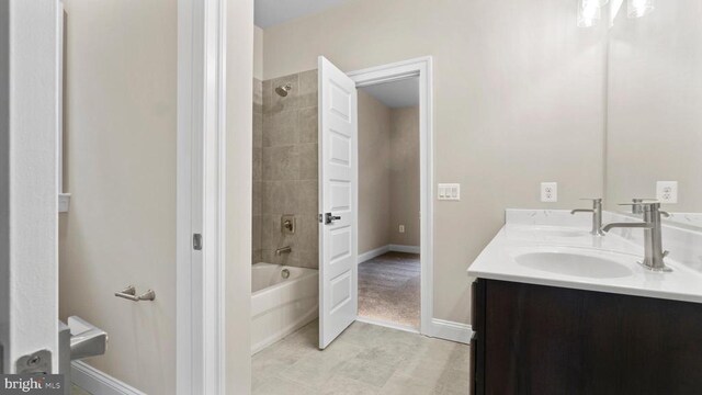 bathroom with tiled shower / bath and vanity