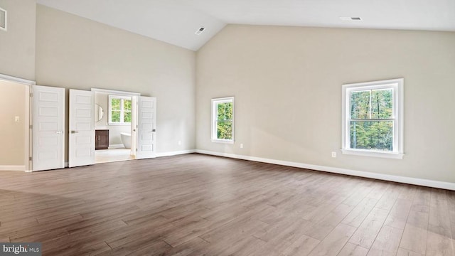 unfurnished living room featuring wood-type flooring and high vaulted ceiling