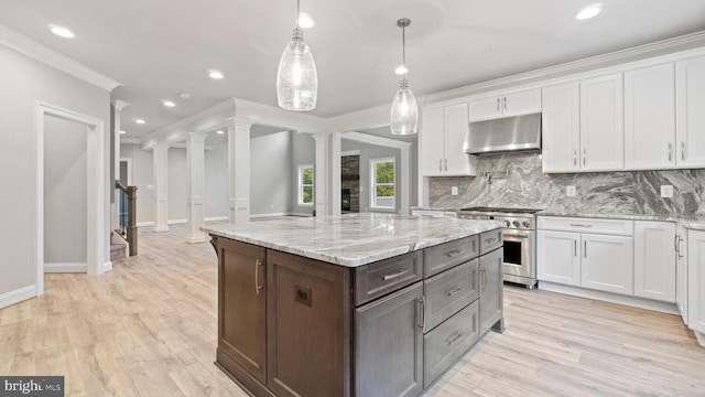 kitchen featuring high end stainless steel range oven, white cabinetry, tasteful backsplash, decorative light fixtures, and ornate columns