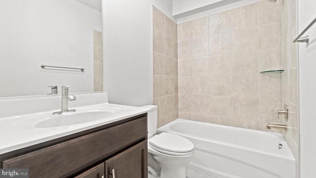 full bathroom with tiled shower / bath, vanity, and toilet