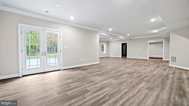 unfurnished living room with light hardwood / wood-style flooring, ornamental molding, and french doors