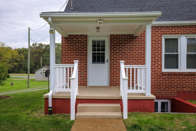 view of exterior entry with a yard