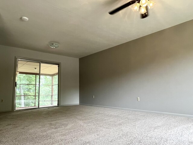 carpeted spare room featuring ceiling fan