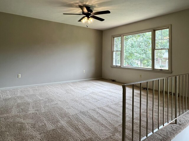 carpeted spare room with ceiling fan