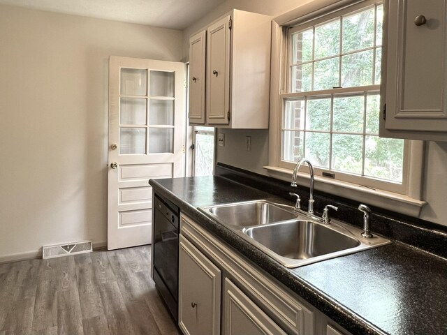 kitchen featuring hardwood / wood-style flooring, dishwasher, sink, and gray cabinetry