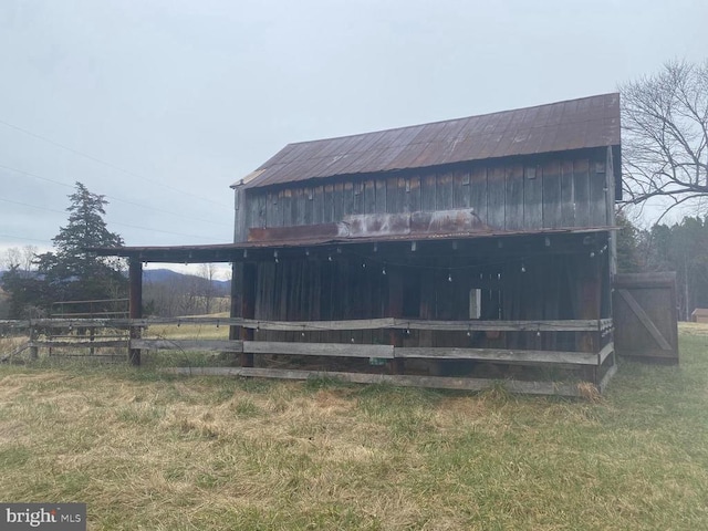 rear view of house featuring an outbuilding, a yard, and a barn