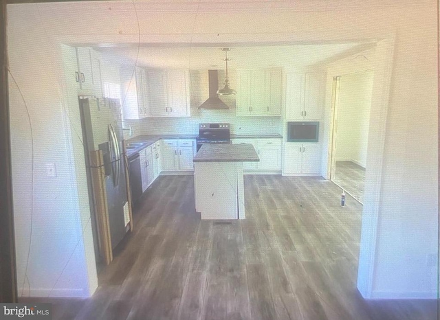 kitchen with light countertops, white cabinetry, a kitchen island, range with electric cooktop, and exhaust hood