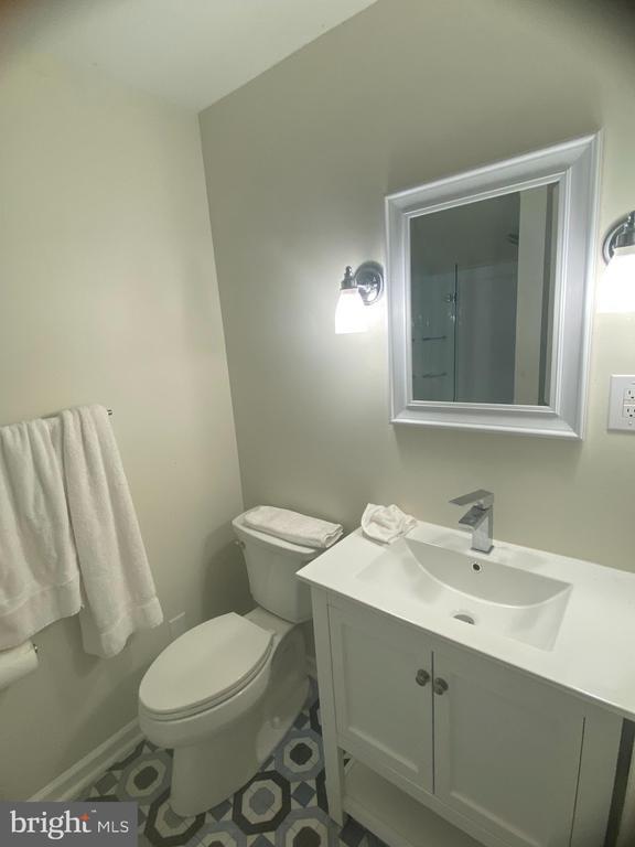 bathroom with tile patterned flooring, vanity, and toilet