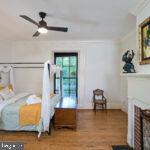 bedroom featuring a brick fireplace and wood finished floors