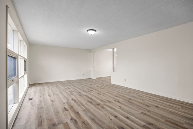 spare room featuring a textured ceiling and light wood-type flooring