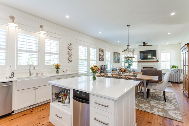 kitchen with sink, white cabinetry, decorative light fixtures, a center island, and stainless steel dishwasher