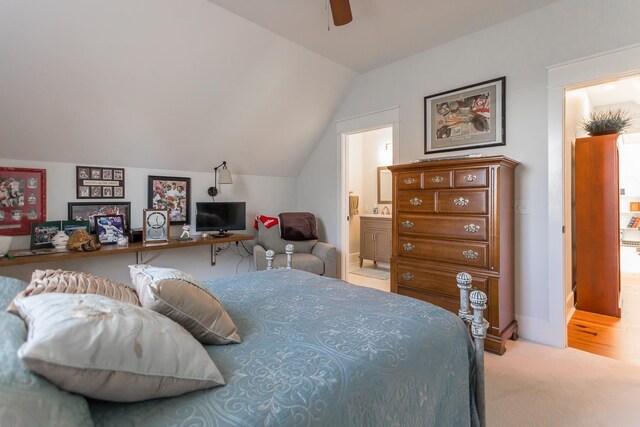 bedroom featuring vaulted ceiling, light colored carpet, ceiling fan, and ensuite bathroom