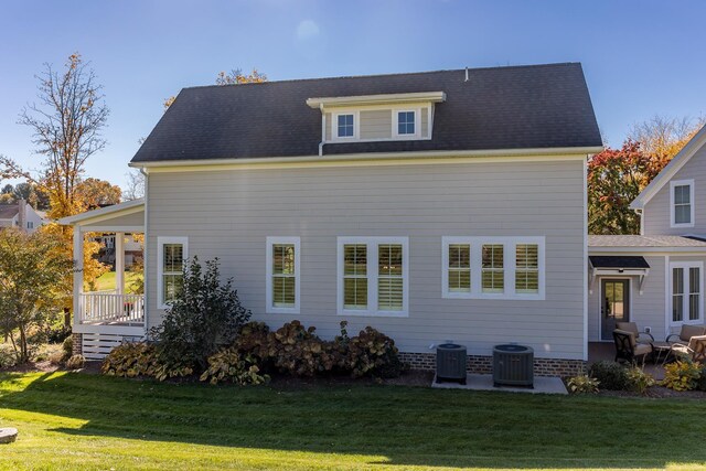 rear view of house featuring a yard and central air condition unit