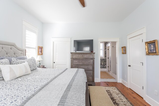 bedroom with hardwood / wood-style flooring and multiple windows