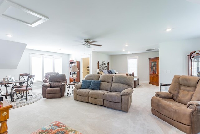 living room featuring plenty of natural light, light carpet, and ceiling fan