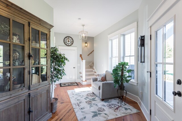 foyer entrance with hardwood / wood-style flooring and a notable chandelier