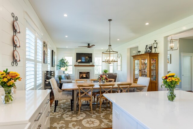 dining space featuring ceiling fan with notable chandelier