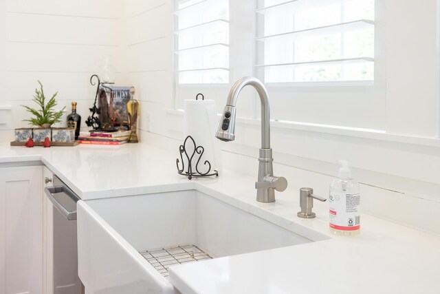 interior details featuring white cabinetry, sink, and stainless steel dishwasher