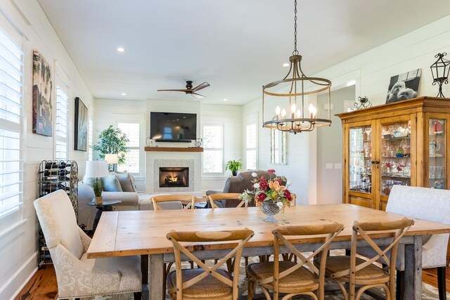 dining room featuring wood-type flooring and ceiling fan with notable chandelier