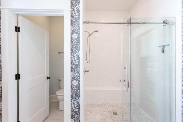 bathroom with a shower with shower door, tile patterned floors, and toilet