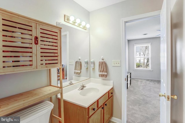 bathroom featuring baseboards, toilet, and vanity