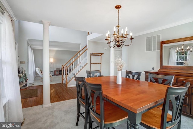 dining space with visible vents, stairway, ornamental molding, a notable chandelier, and ornate columns