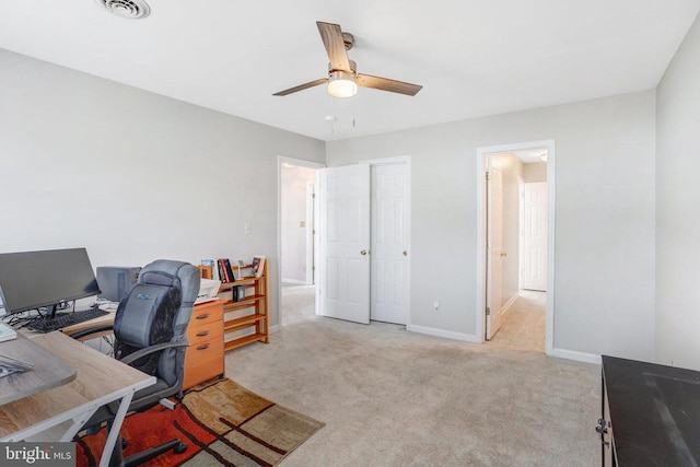 office area with carpet flooring, visible vents, baseboards, and a ceiling fan