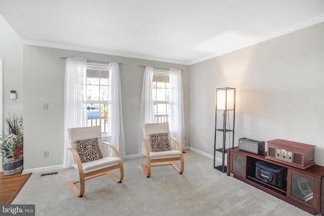 living area with visible vents, carpet flooring, baseboards, and ornamental molding